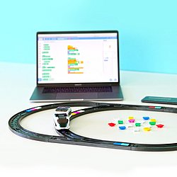 Ein Laptop vor dem Spielzeugschienen mit einem Spielzeugzug aufgebaut sind